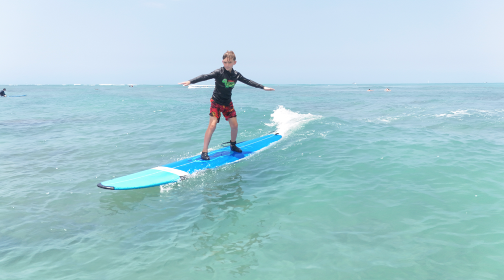 a girl riding a wave on a surf board on a body of water